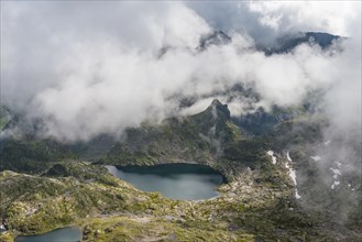 Clouds passing over a ridge by a mountain lake