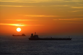 Cargo ships lying on roadstead at sunrise