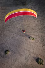 Paraglider over ploughed field