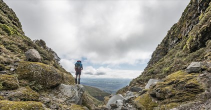 Hiker stands on slope