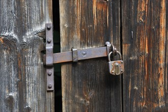 Rusty door handle with door lock on old wooden door