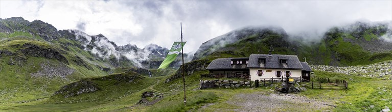 Landawirseehutte and Alpine Club flag with cloudy Alpine valley
