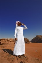 Bedouin uses his smartphone at Rock Arch