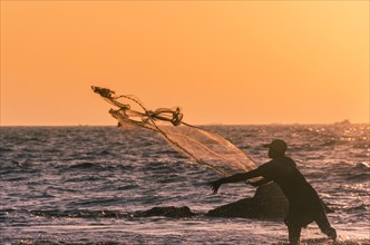 Local fisherman casts fishing net