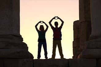 Couple forms a heart in sunset at the Temple of Hercules at the Citadel