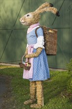 Easter bunny as straw doll with egg basket