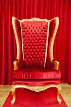 Red royal throne and red curtain behind
