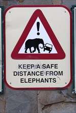 Warning sign keep safe distance from elephants
