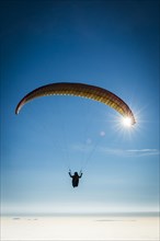 Paraglider over cloud cover