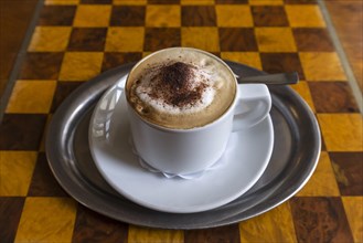 Cappuccino on table with chessboard pattern