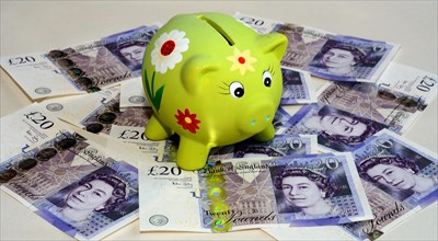 Piggy bank on twenty pound British banknotes