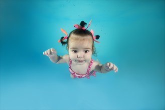 Little girl In a pink swimsuit diving in the swimming pool