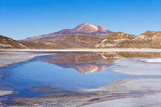 Volcano Cerro Tunupa with reflection in the Salar de Uyuni