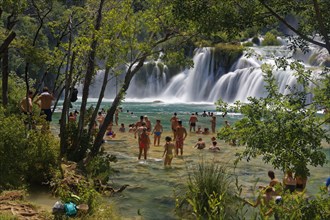 Tourists bathe at the waterfall Smotorcycleinski Buk