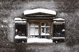 Snow-covered window on old farmhouse