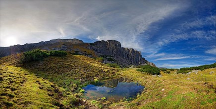 Small mountain lake with Klobenjoch north face