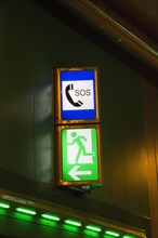 Illuminated emergency exit and SOS signs in a road tunnel