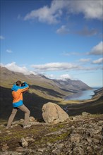 Photographer photographs view from Mjoafjaroarheioi Pass onto Mjoifjorour Fjord