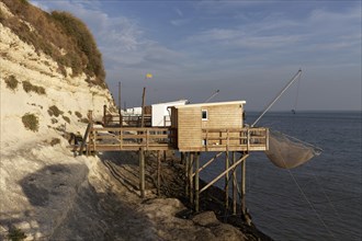 Traditional fishing huts built on stilts with fishing nets on the shore