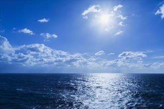 Late afternoon sun through cumulus clouds over the Mediterranean sea off the coast of Italy