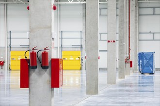 Modern empty storehouse with fire extinguishers