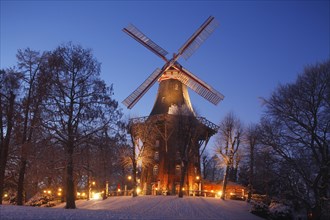 Illuminated Herdentorswallmuhle wind mill in the ramparts with snow