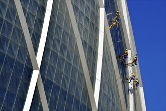 Window cleaners hang on The Coin building