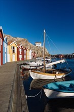 Boats and colourful boathouses in the harbour of Smogen