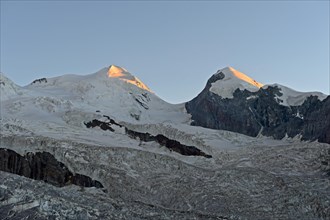First rays of sunshine at the Castor and Pollux peaks above the border glacier