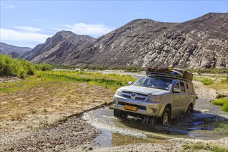 Off-road vehicle crosses Hoarusib River