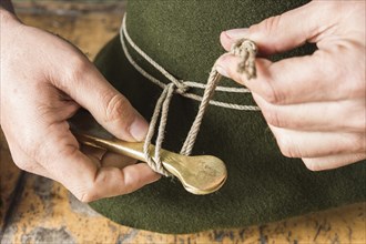 Tightening the shaping cord around a wool felt hat