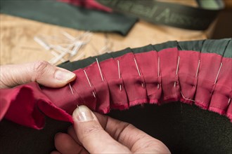 Hands folding and fastening silk ribbon using pins