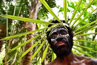 Korafe man with face painting and headdress made of leaves