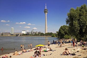 Bathers on the beach on the Rhine with Rhine Tower