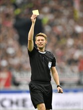 Referee Christian Dingert displays yellow card