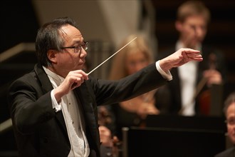Conductor Shao-Chia Lu conducting at concert