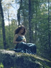 Artistic tranquil portrait of a beautiful young woman in a green dress