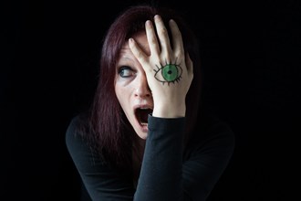 A screaming woman with a painted eye on her hands
