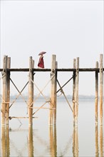 Monk crossing U Bein bridge