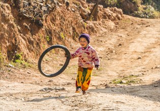 Little boy runs with tire as toy