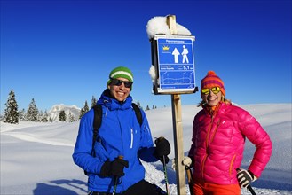 Hikers in the snow on the signposts Panoramaweg