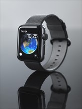 Shiny steel Apple Watch series 2 smartwatch with clock displaying Earth