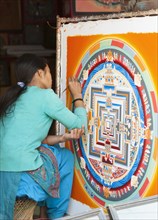 Female artist working on a mandala in a local handicraft shop