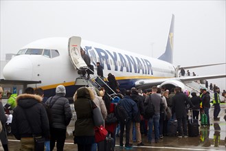 Passengers boarding Boeing plane in bad weather