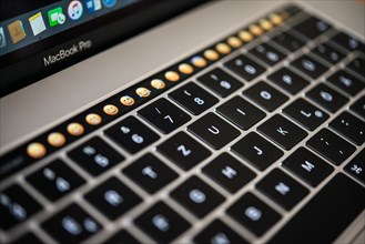Backlit keyboard and Touch Bar showing emoticons