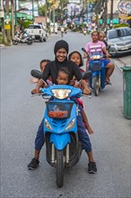Mother with three children on scooter