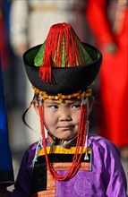 Little girl in traditional Deel clothes and hat with cone-shaped lace
