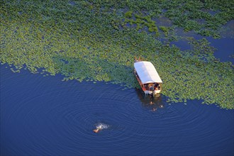 Boat and bathers in the river Rijeka Crnojevica