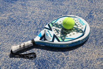 A padel racket and a ball on a padel field