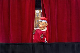 Puppet looking through curtain